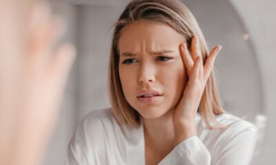 Ragazza che si guarda allo specchio il viso