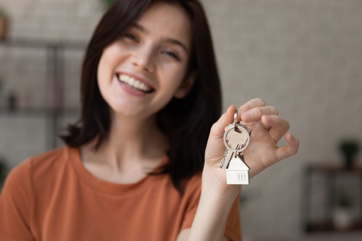 Ragazza che sorride con chiavi di casa in mano