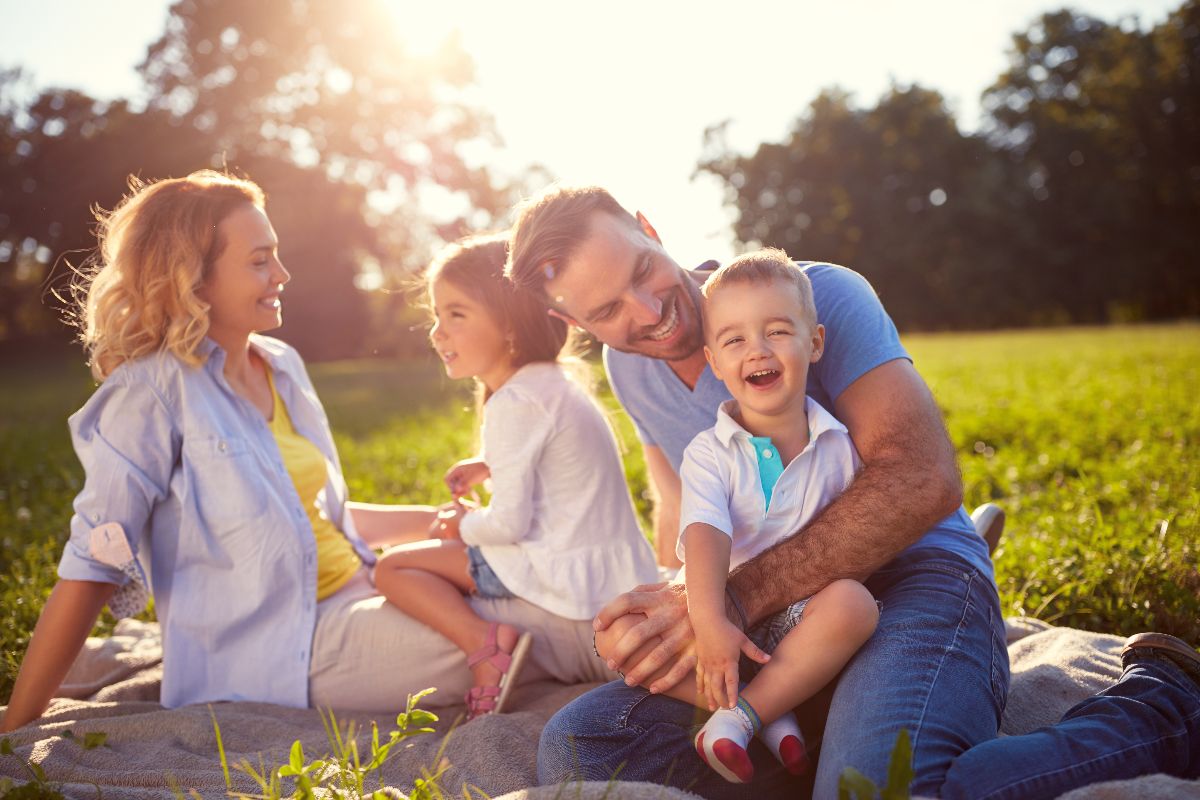 Una famiglia sorridente su un prato in una giornata primaverile