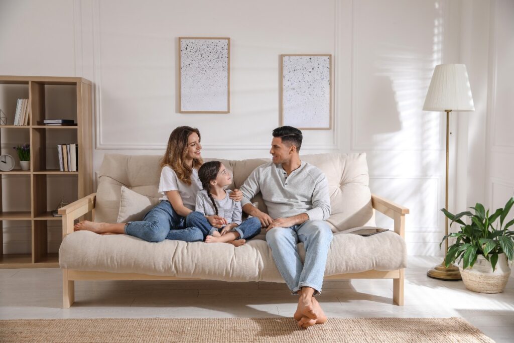 Famiglia riunita sul divano in salotto