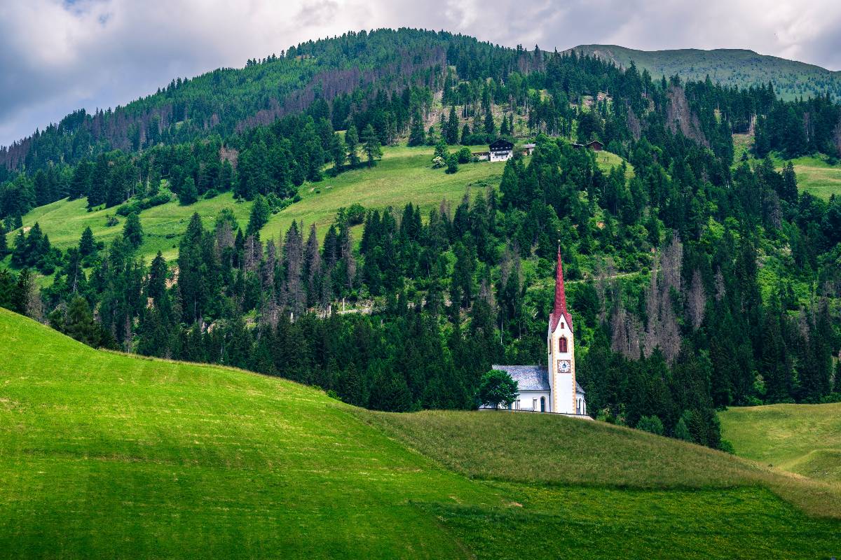 Chiesa tipica dell'Alto Adige tra i prati verdi della Val Pusteria.